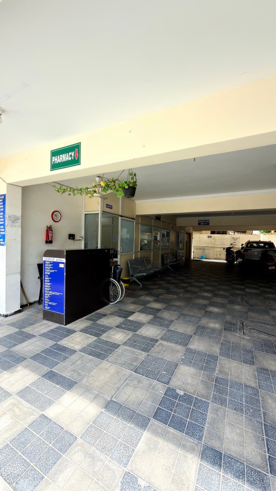 The covered entrance, with the pharmacy and the emergency room signposted from the gate.